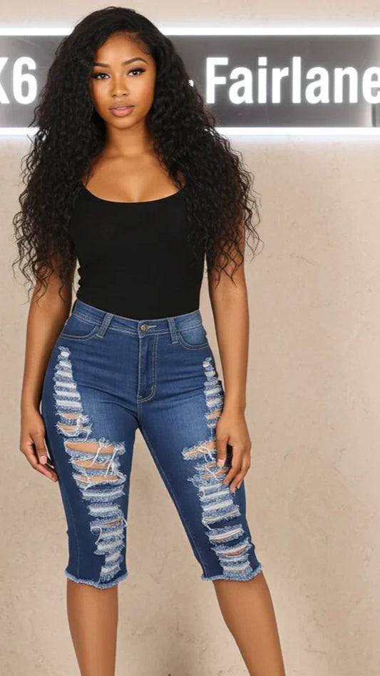Woman wearing ripped blue jeans and a black top against a beige background with 'K6 Fairlane' branding.