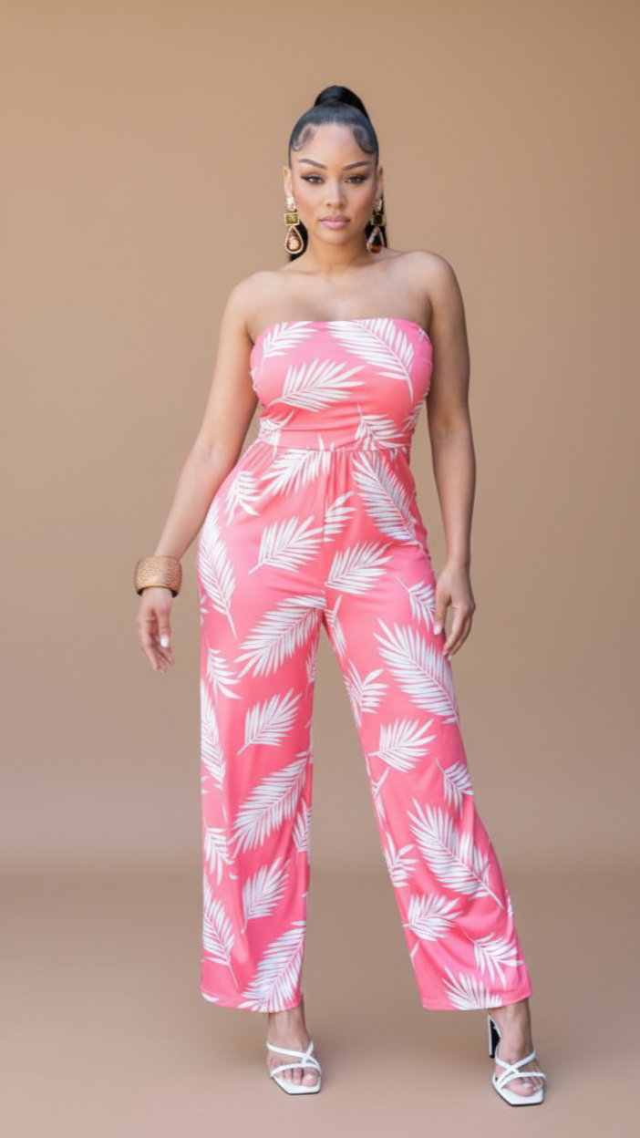 Woman wearing a pink strapless jumpsuit with white leaf pattern on a beige background